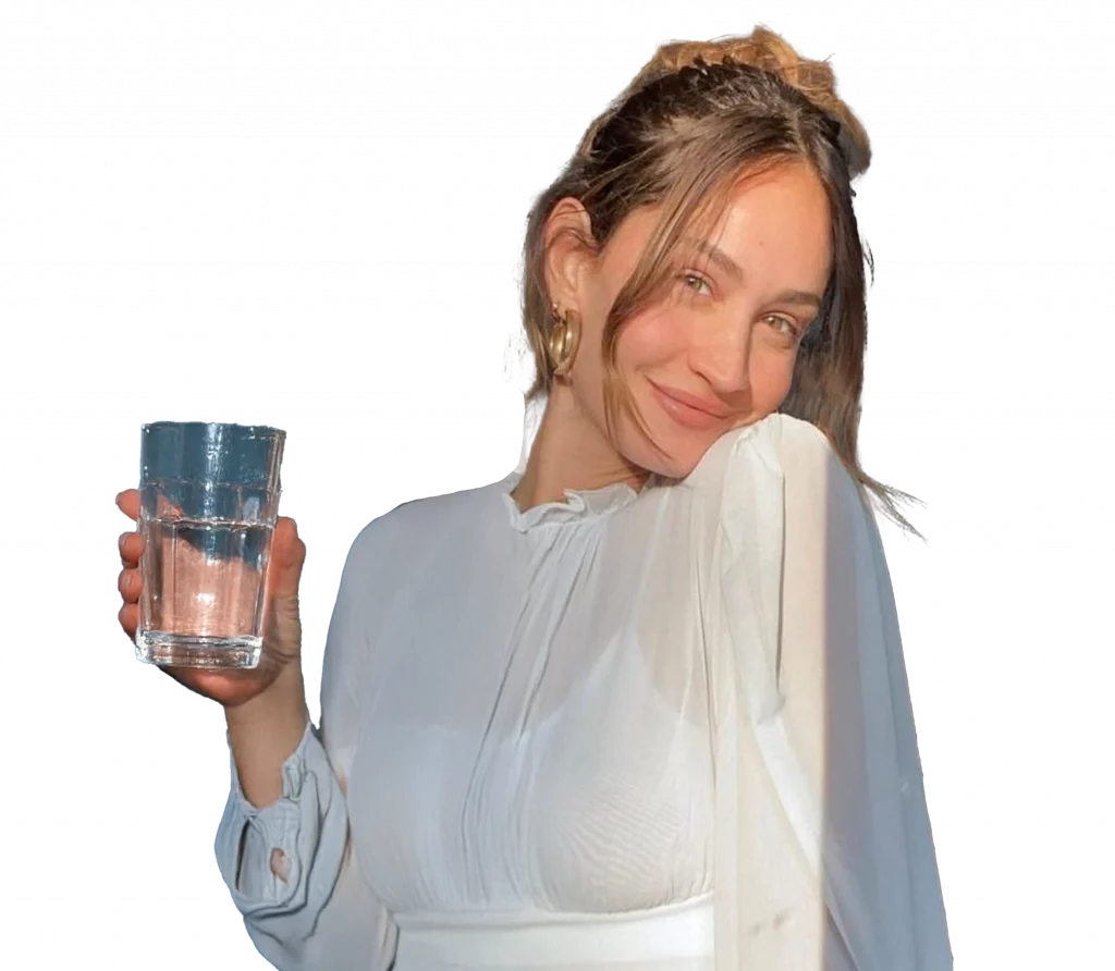Foto influencer Helena Prestes che tiene un bicchiere d'acqua in mano